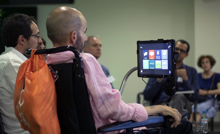 Hombre con un comunicador en su silla de ruedas. Imagen de Tecnobility