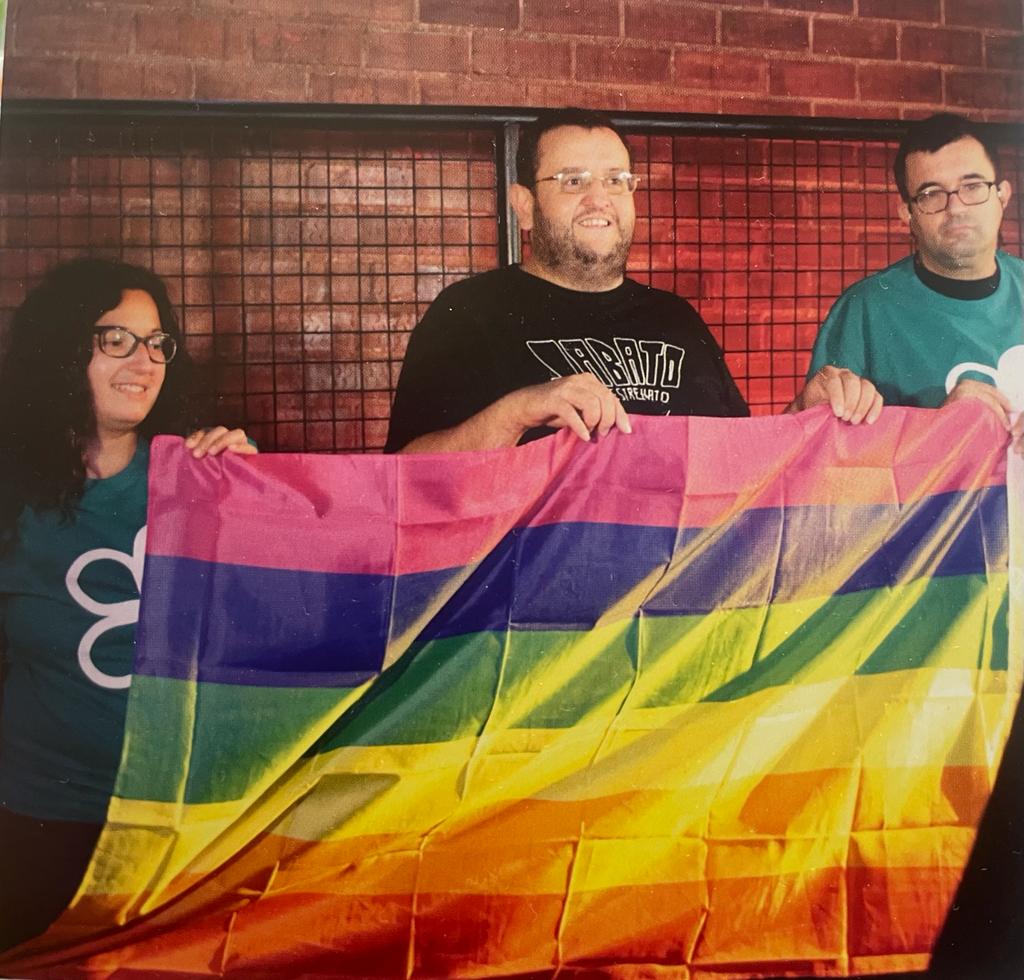 Personas sostienen una bandera del Orgullo