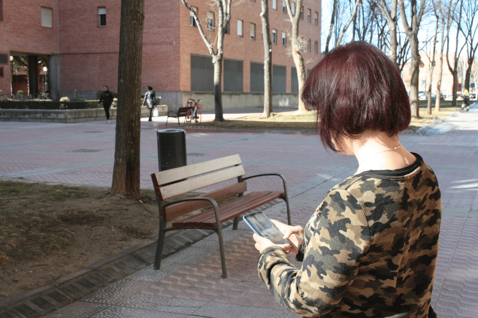 Una mujer usa un móvil en la calle