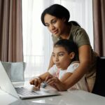 foto madre ayudando niña hija ordenador tecnología - pexels